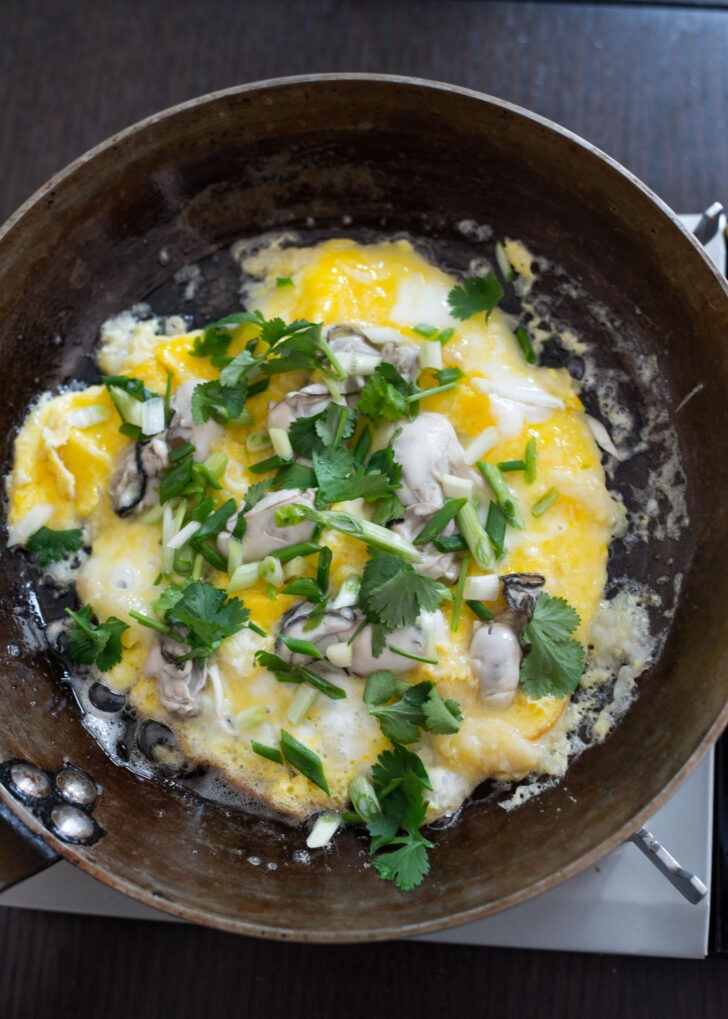 Green onion and cilantro topping over oyster omelette.