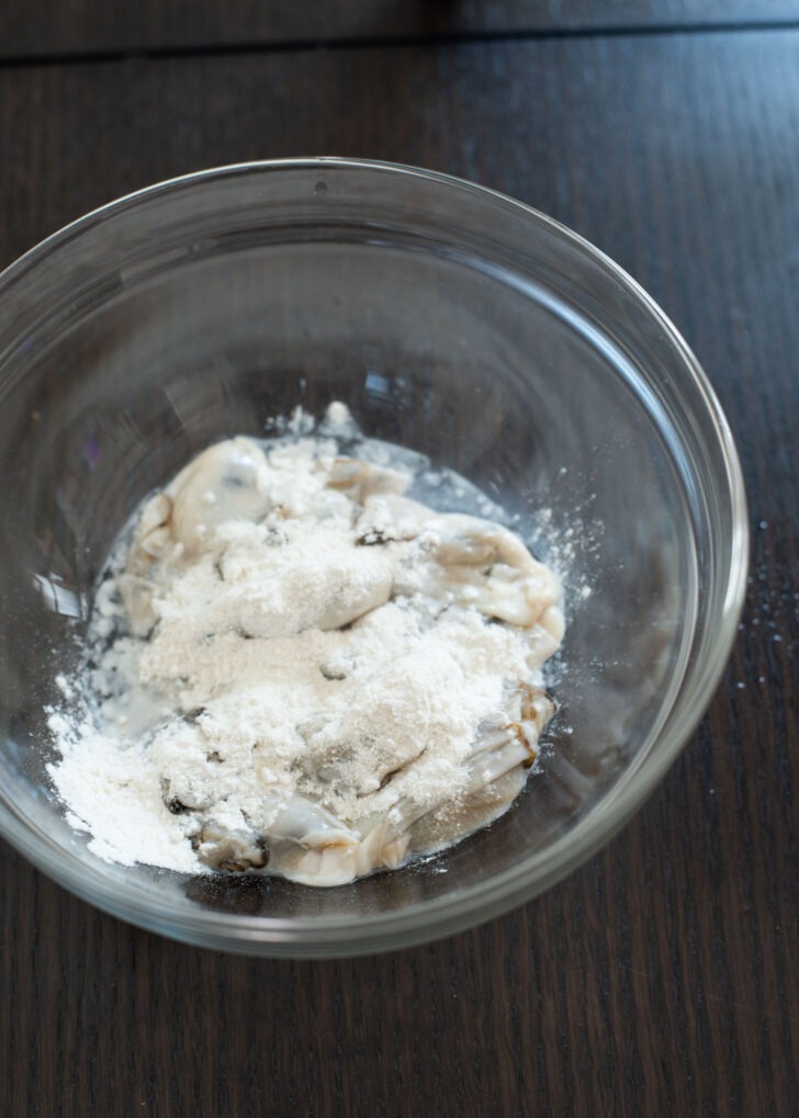 Flour to fresh oysters in a bowl.