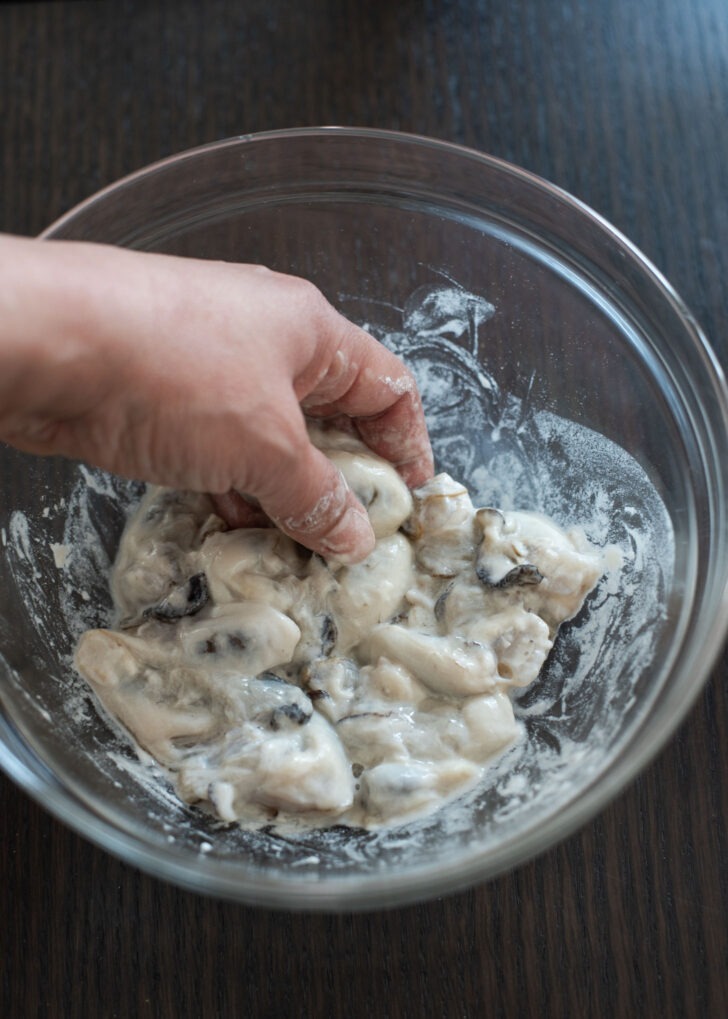 Rubbing oysters with flour.