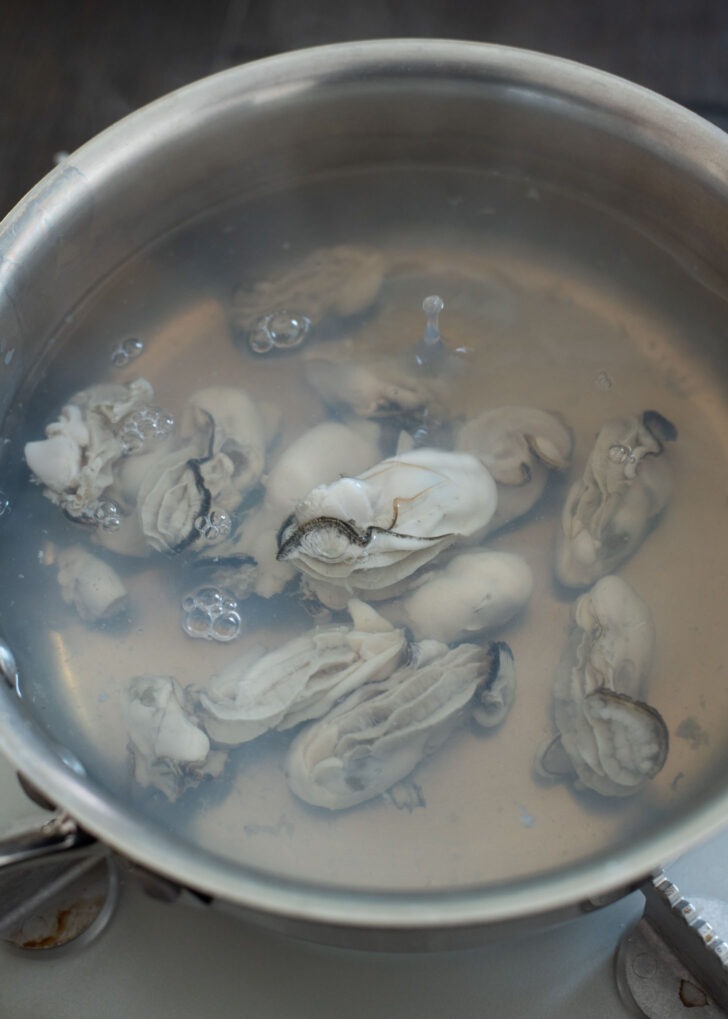 Fresh oysters to boiling water in a pot.