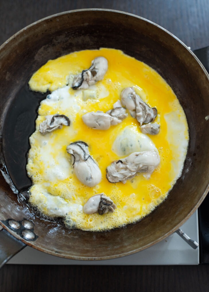 A few pieces of oyster added on semi-scrambled egg.