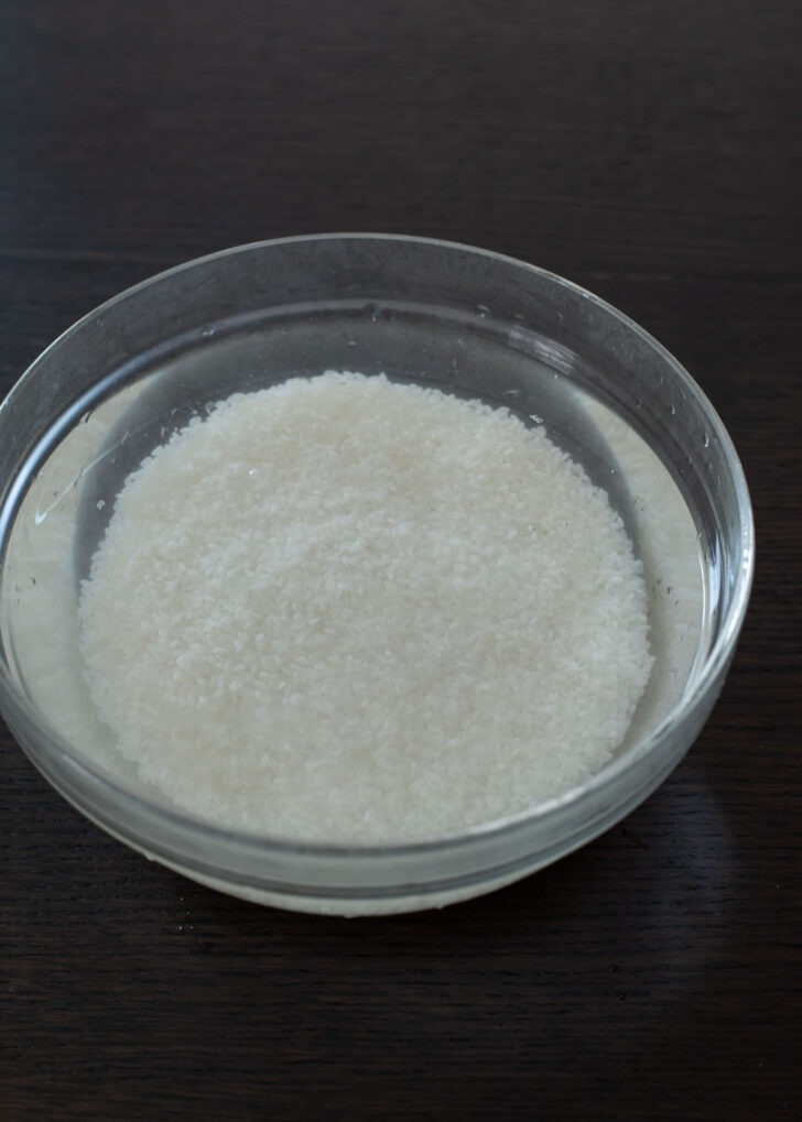 Rinsed short grain rice (Korean rice) in a bowl with almost clear water.