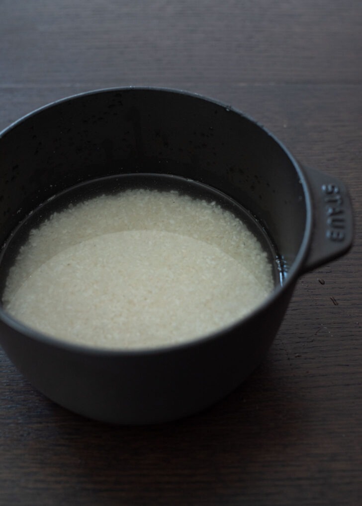 Short grain Korean rice soaking in water in a heavy pot.