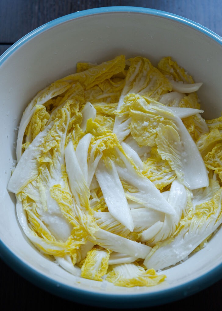 Salt brined cabbage leaves in a bowl.