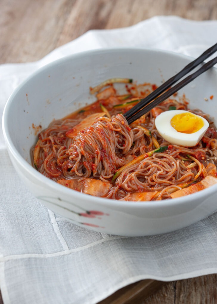 bibim naengmyeon korean spicy cold noodles with egg and chopsticks