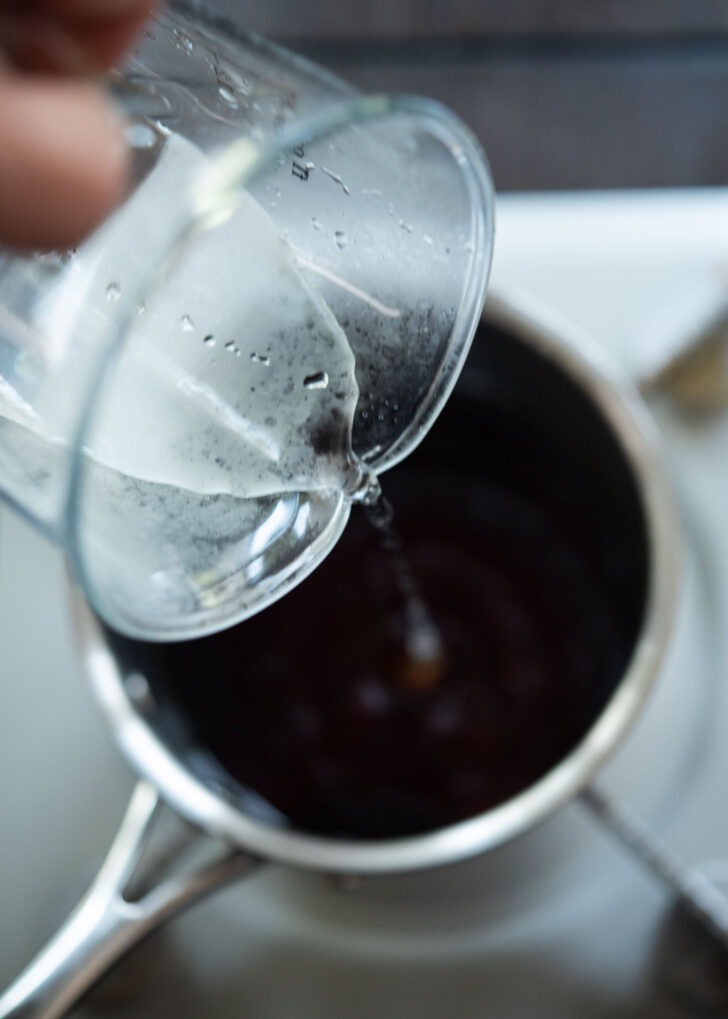 Soy sauce and water combined in a pot.