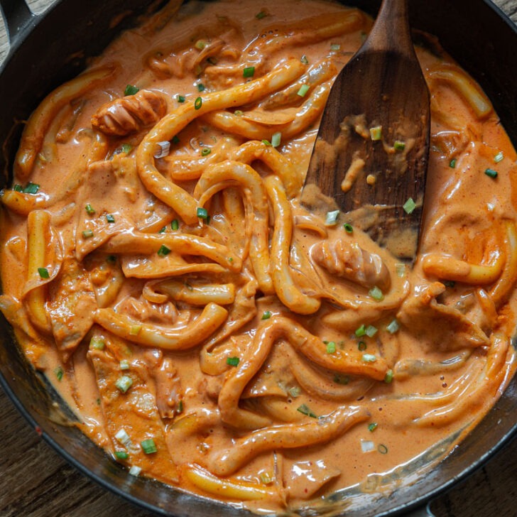 Rose tteokbokki with sausage in a creamy gochujang rose sauce.