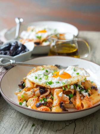 Kimchi olive pasta featuring feta cheese and fried egg as a Greek-Korean fusion dish.