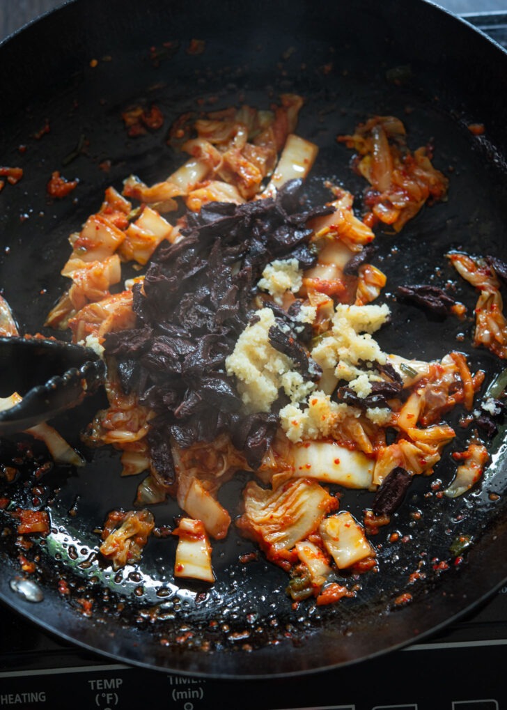 Olives and garlic are added to fried kimchi to make kimchi olive pasta. 