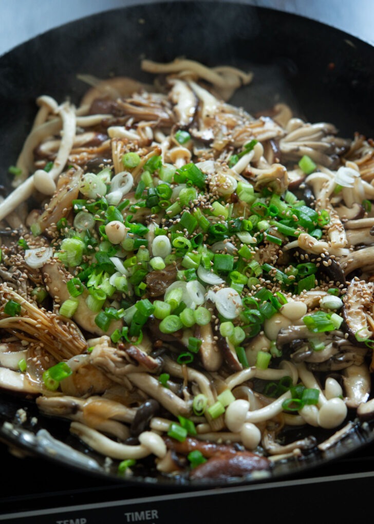 Chopped green onion added to mushroom stir-fry.