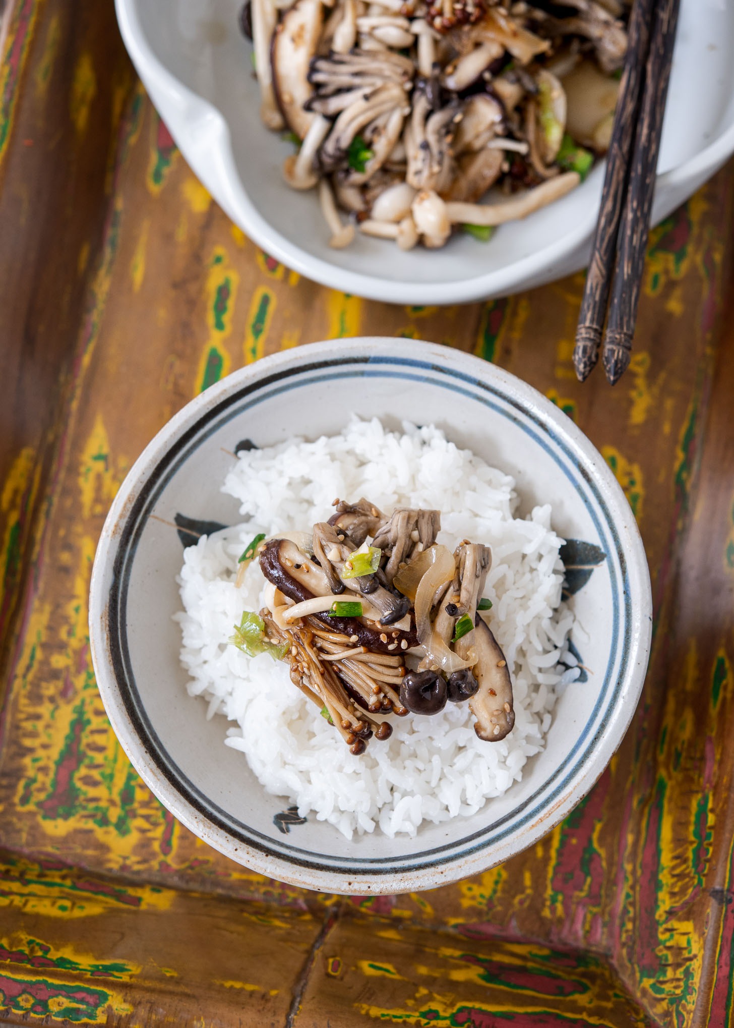 Korean mushroom stir-fry over a bowl of white rice.