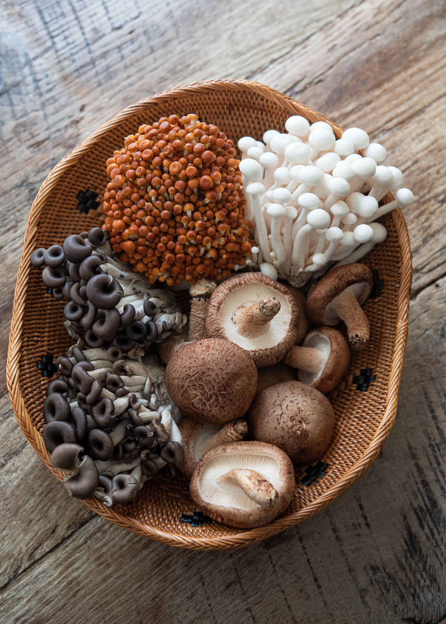Various Asian mushrooms in a basket.