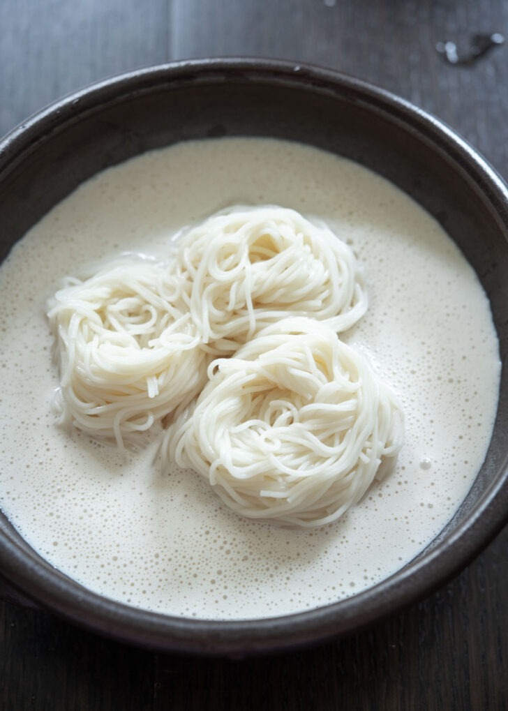 Somen noodles are added to a bowl of soy milk soup base.