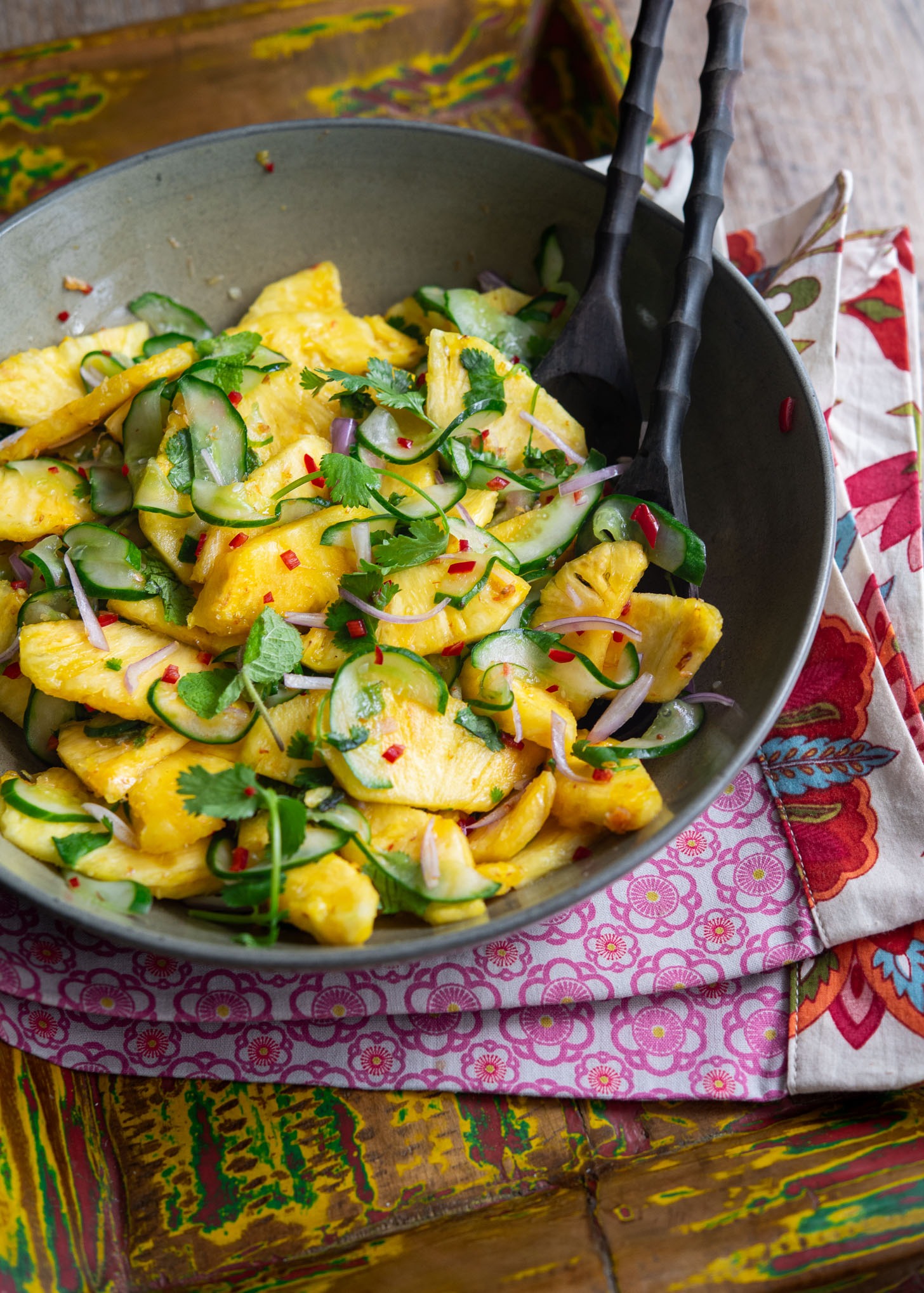 Refreshing Pineapple and cucumber tossed with herbs in a bowl.