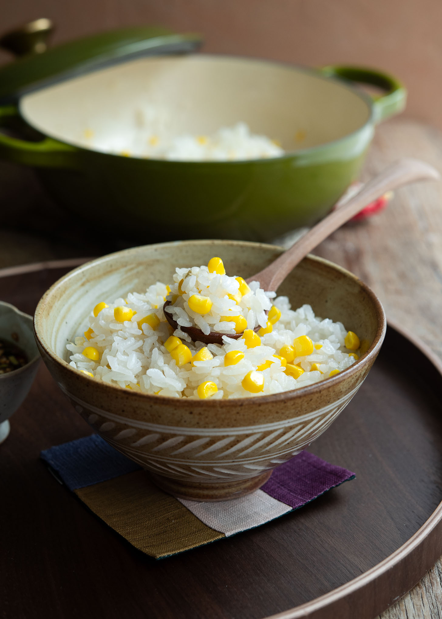 Oksusubap, corn rice, served in a bowl with a spoon.