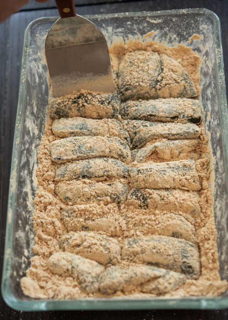 Mugwort injeolmi coated with roasted soybean flour are cut with spatula.