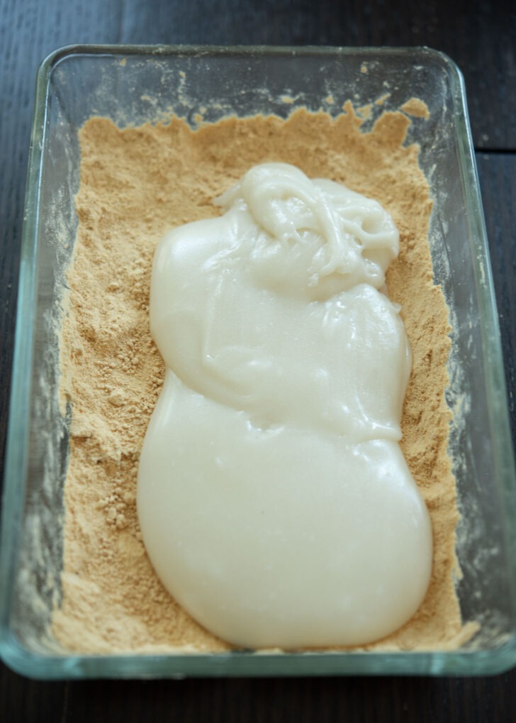 Sticky injeolmi dough is added on top of roasted soybean powder.