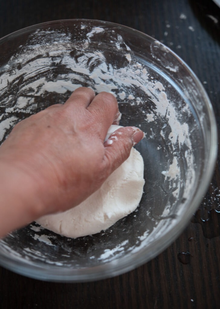 Hand kneading the rice cake dough to get soft and chewy texture.