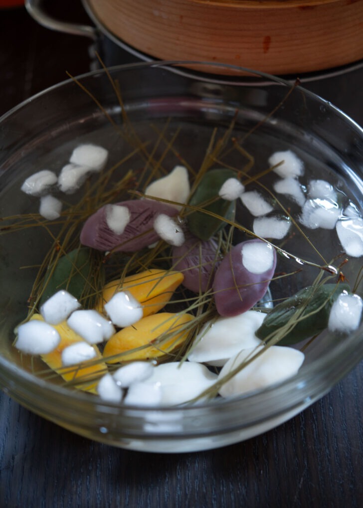 Steamed songpyeon immersed in a bowl of ice water.