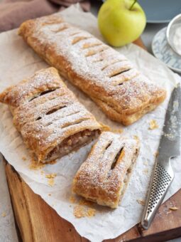 Apple strudel dusted with powdered sugar and sliced.