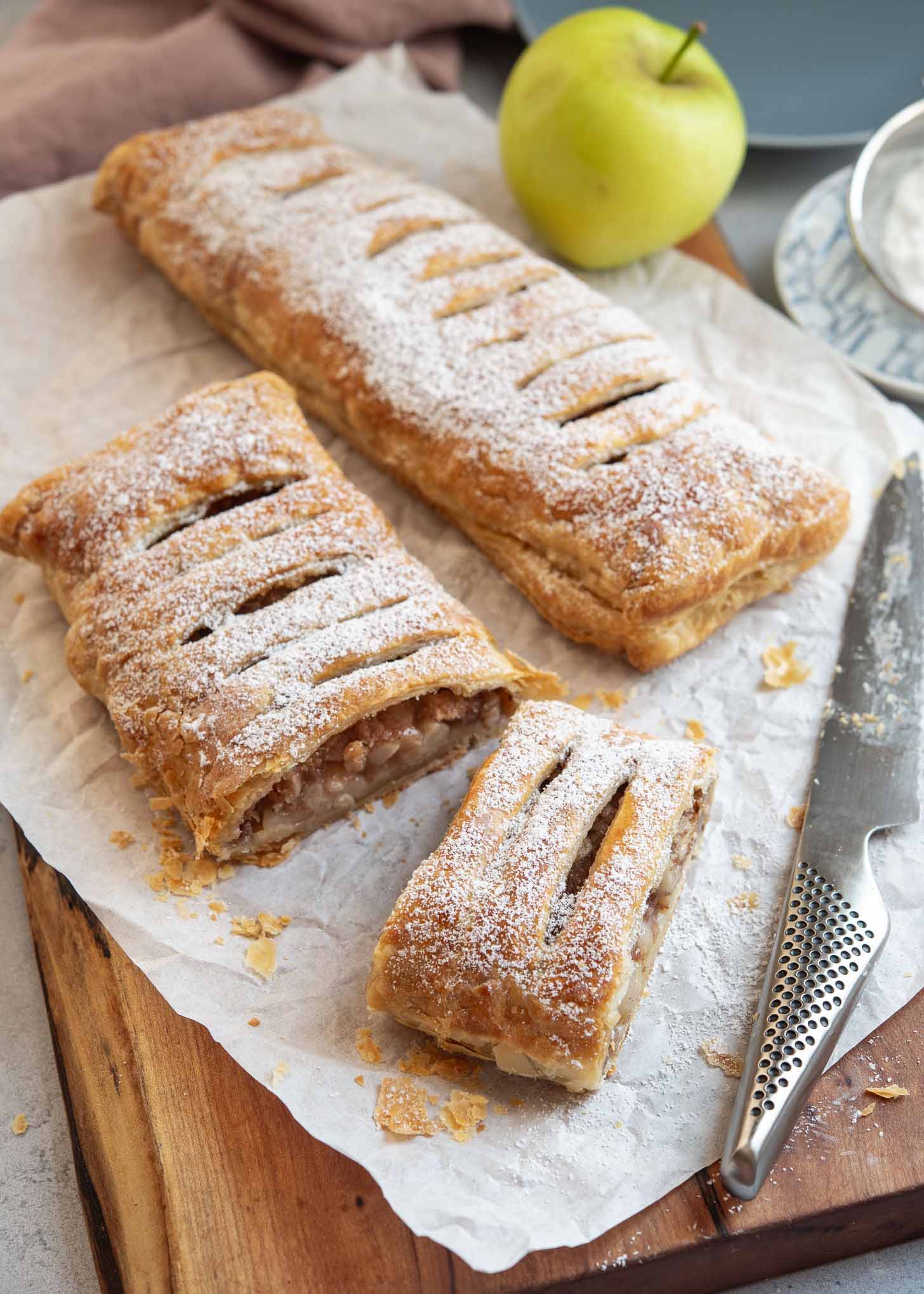 Apple strudel dusted with powdered sugar and sliced.