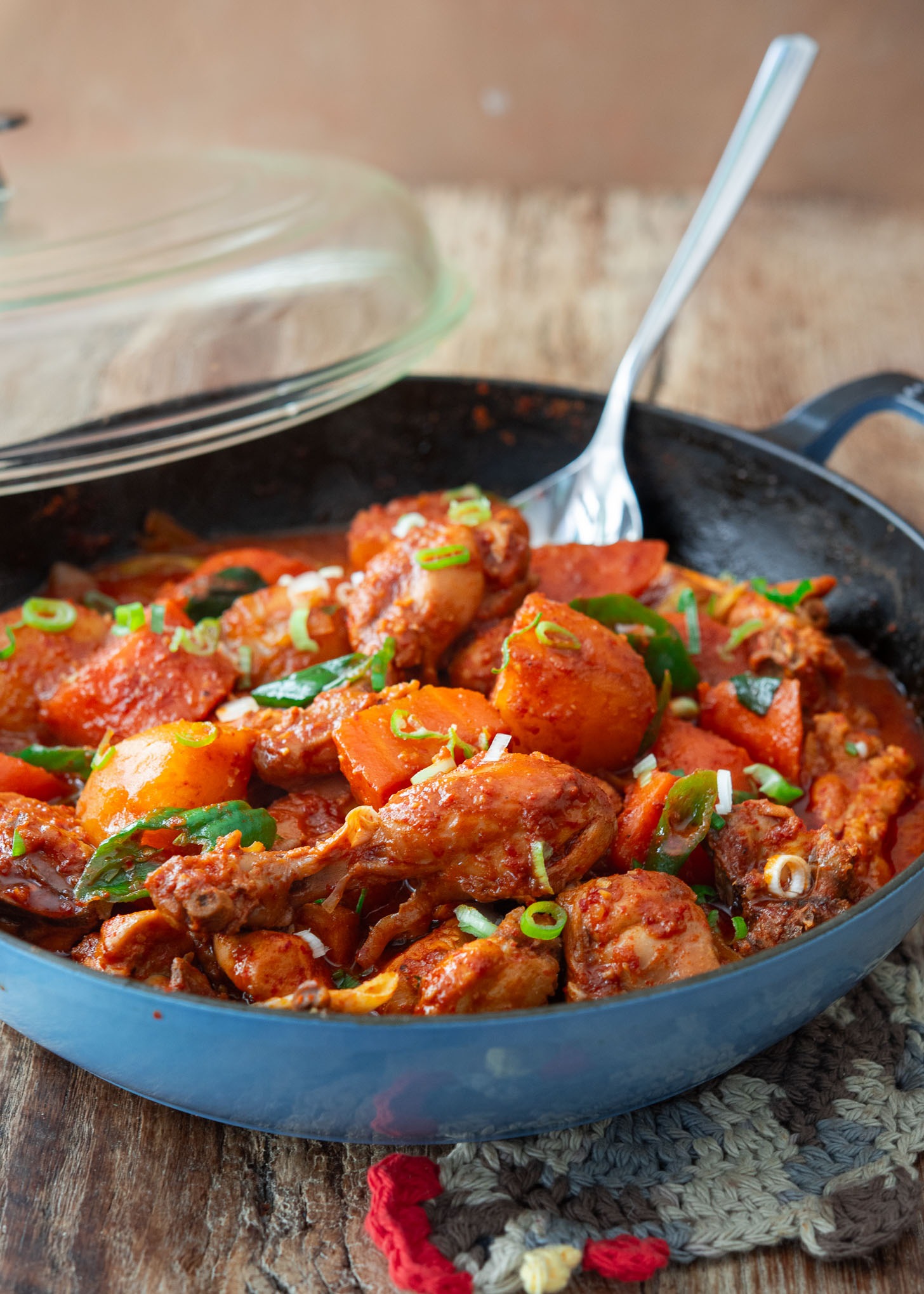 Spicy Korean chicken stew with carrot and potato in a braising pan.