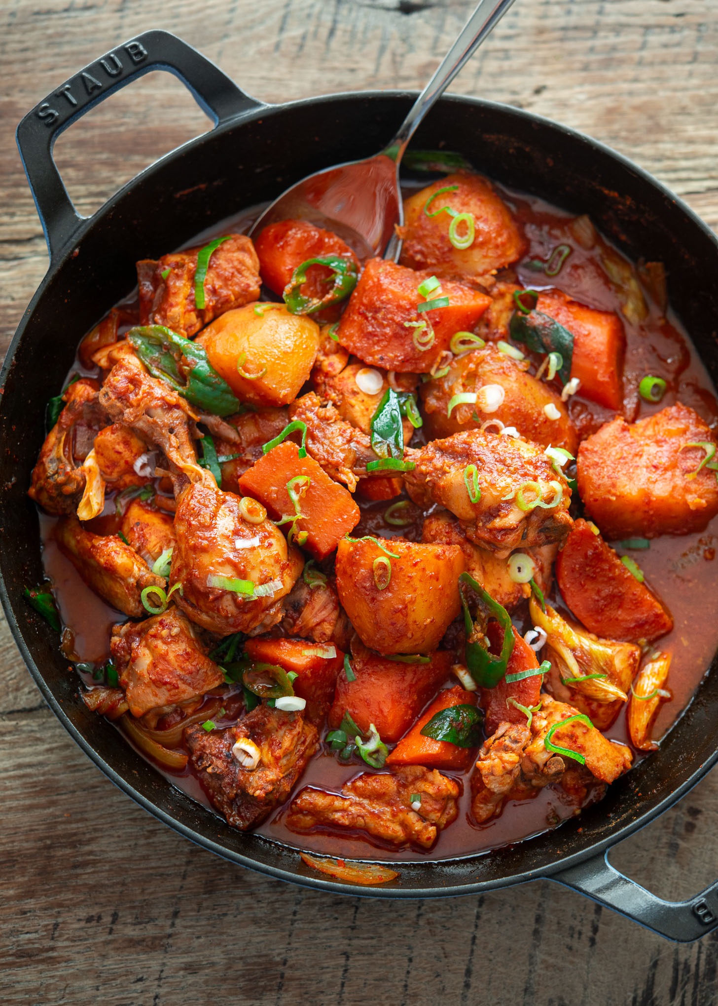 Braised Korean spicy chicken stew (Dakdoritang) with red sauce in a pan.