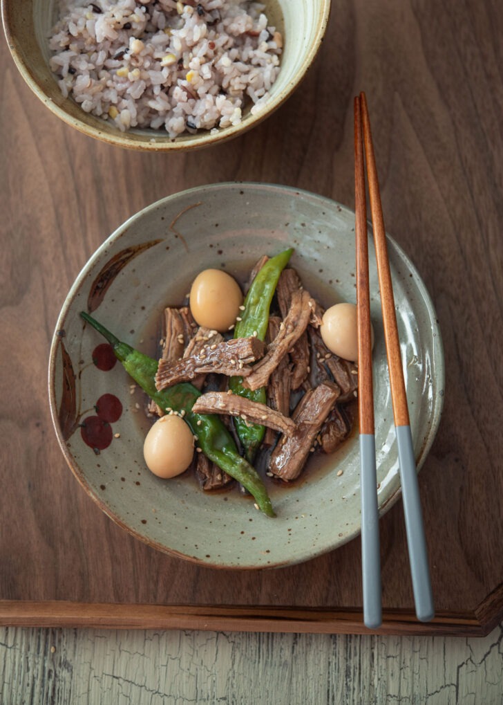 Jangjorim (Korean soy braised beef) with eggs and pepper on a tray.