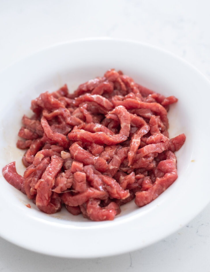 Beef strips mixed with seasoning marinade.