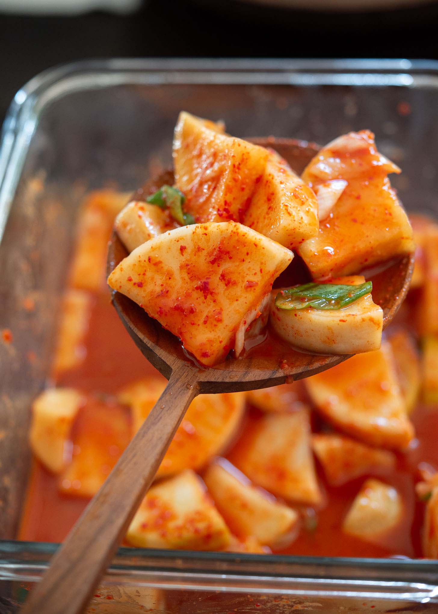 A ladleful of fermented radish kimchi (kkakdugi).