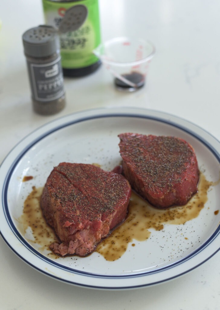 Two pieces of beef tenderloin seasoned with soy sauce and pepper.