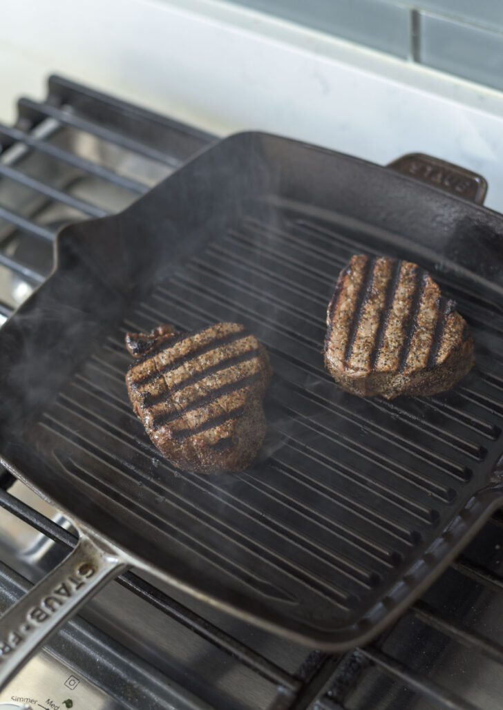 Beef tenderloin is grilled on a pan showing grill mark.