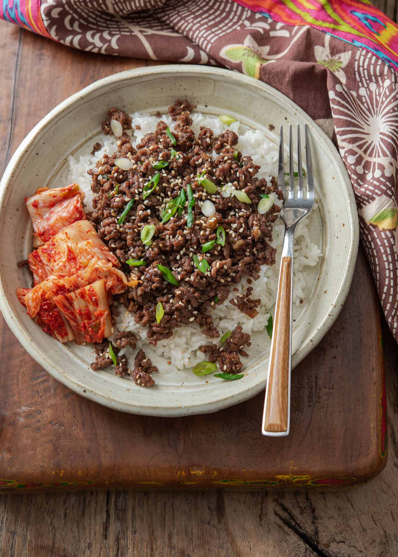 Korean beef and rice bowl made with ground beef bulgogi in a serving bowl with kimchi.