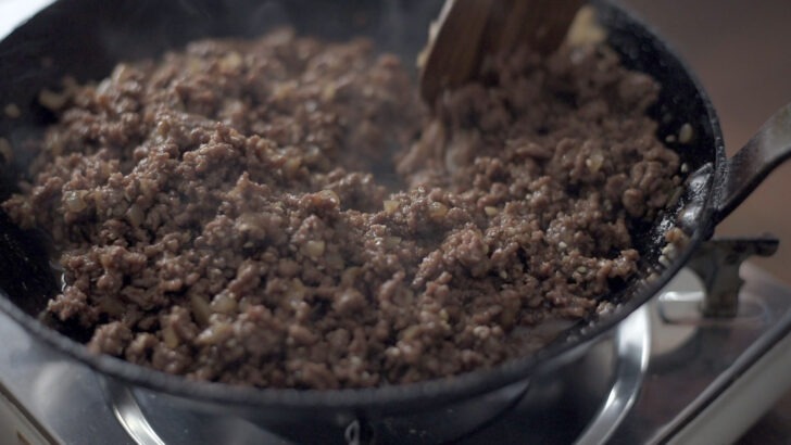 Ground beef cooking in bulgogi sauce in a skillet for bibimbap.