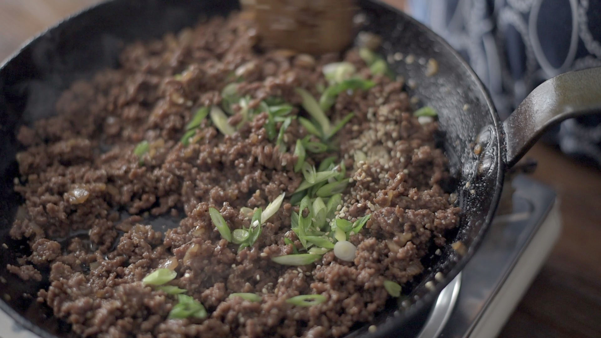 Green onion added to garnish ground beef bulgogi at the end.