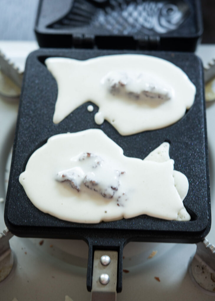 Pouring fish bread batter to cover the red bean filling on top.