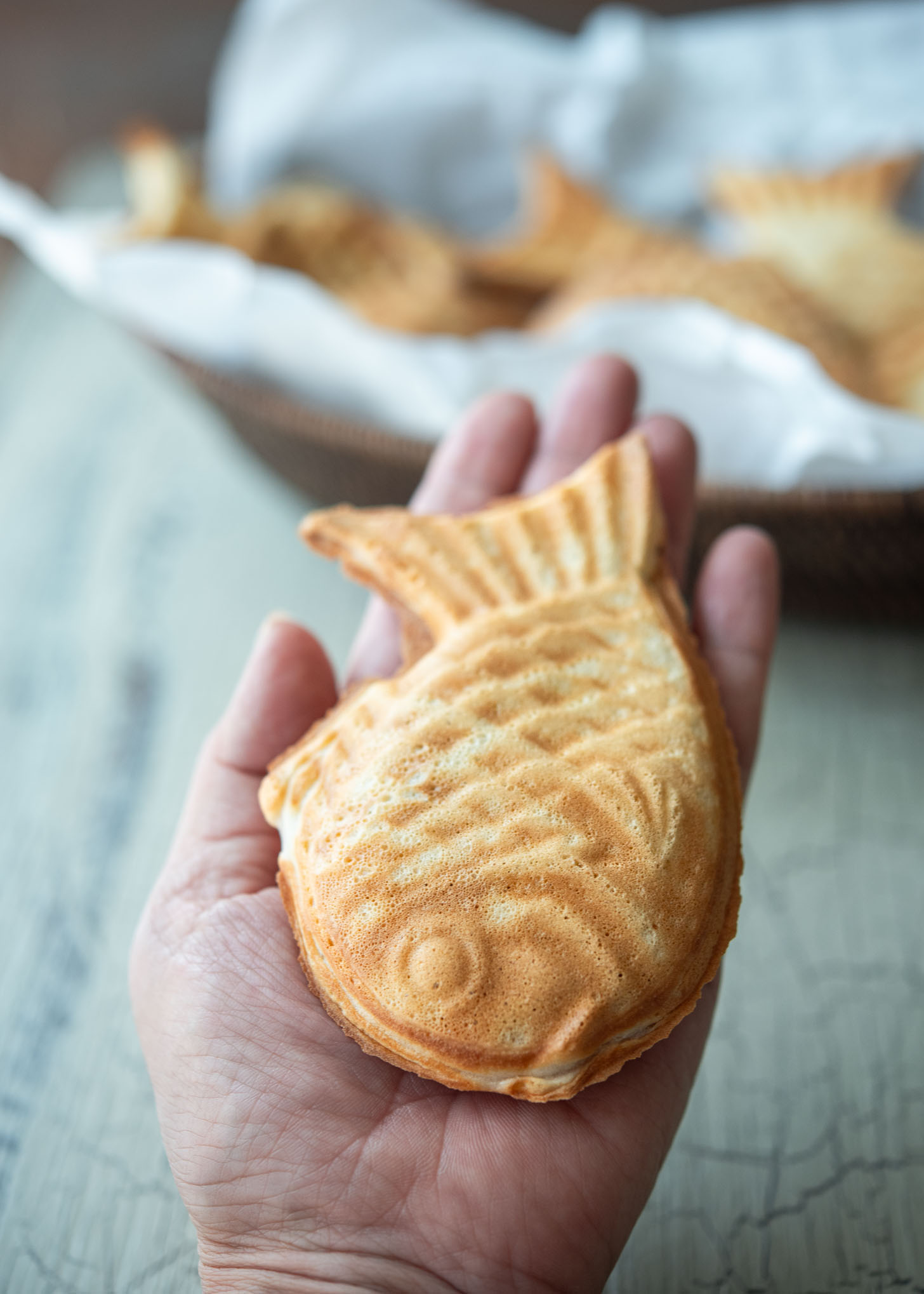 A hand holding a bungeoppang fish pastry.