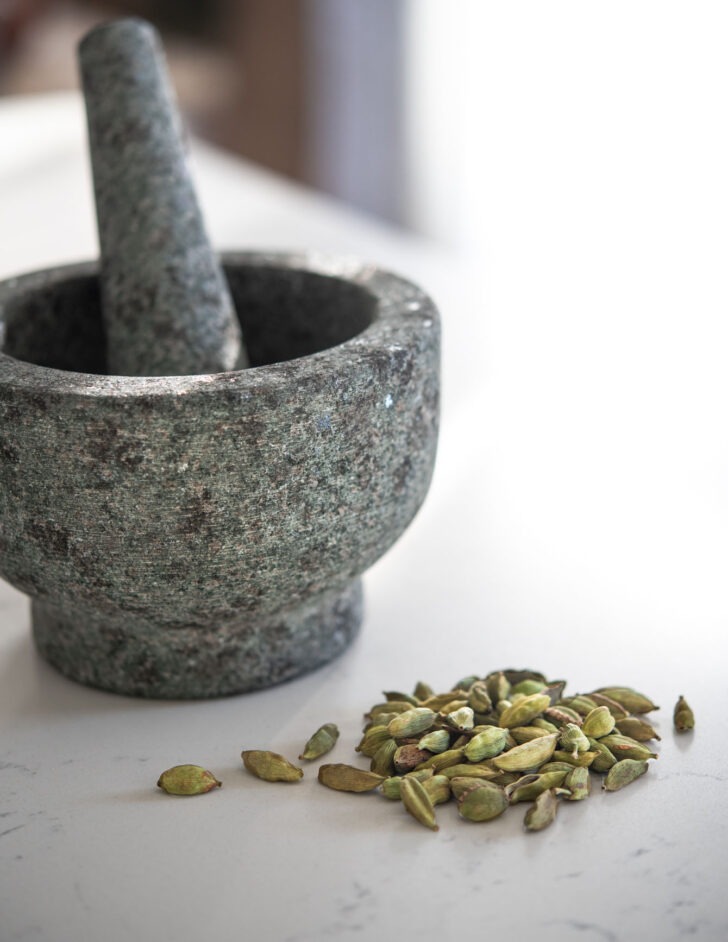 cardamom pods with mortar and pestle.