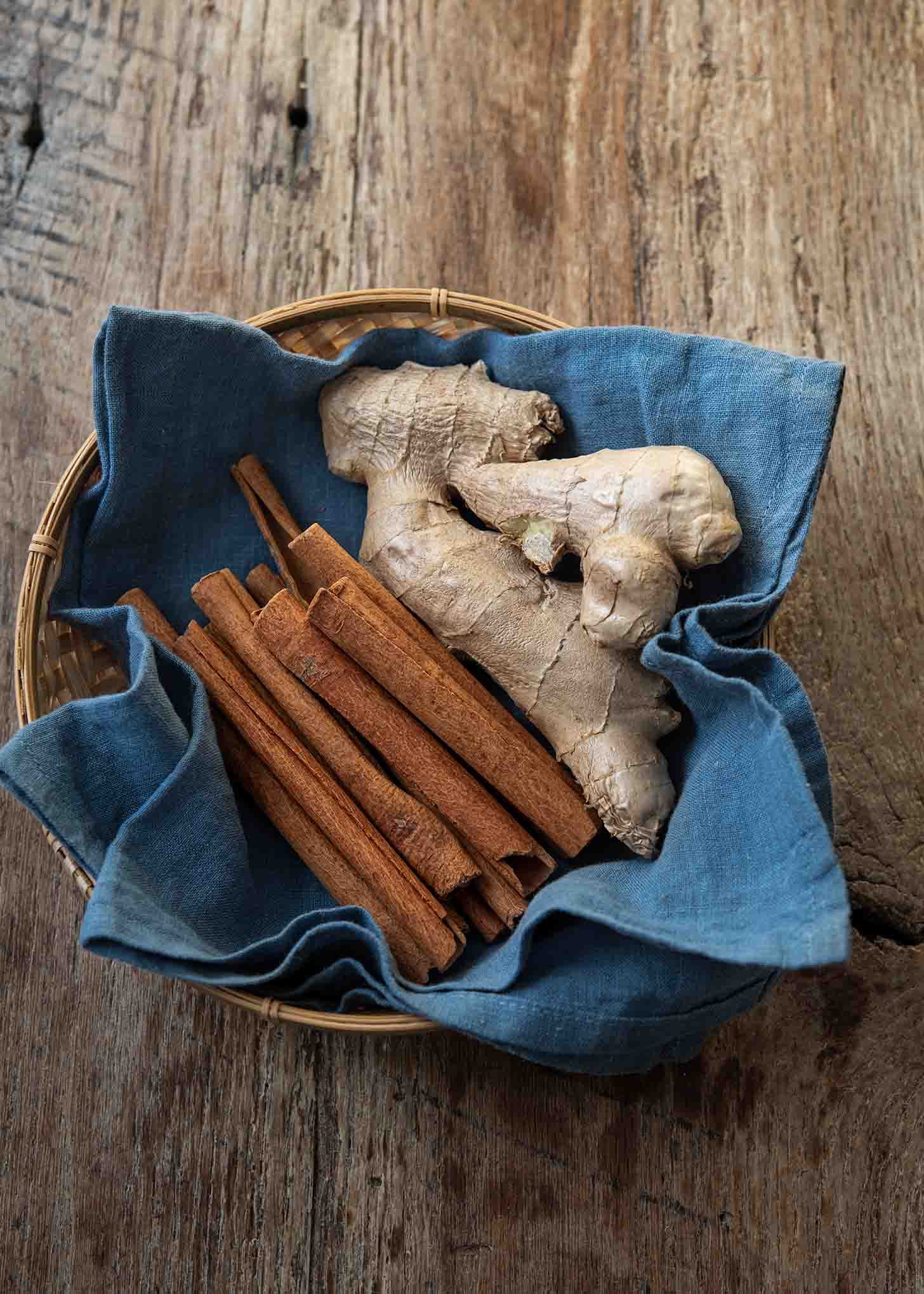 Cinnamon sticks and ginger root in a basket.