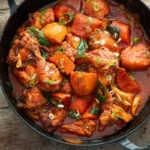 A pan filled with spicy Korean chicken stew with vegetables.