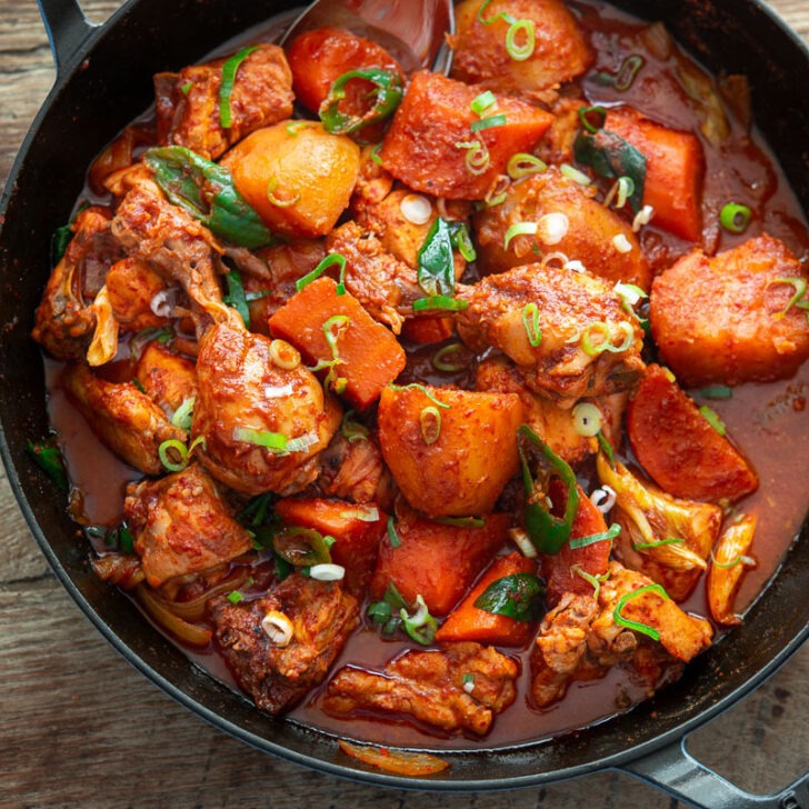 A pan filled with spicy Korean chicken stew with vegetables.