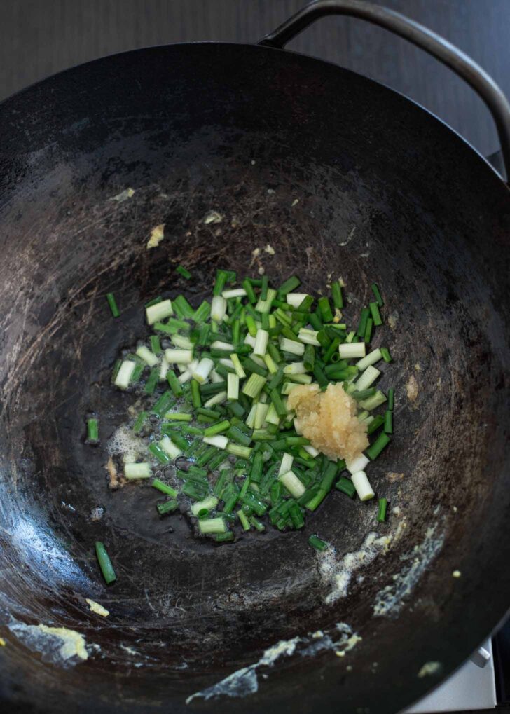 Green onion and garlic cooking in a wok,