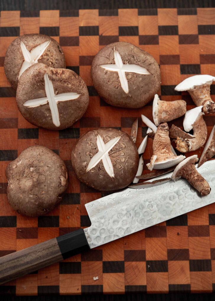 Scoring cross pattern on top of mushroom with a knife.