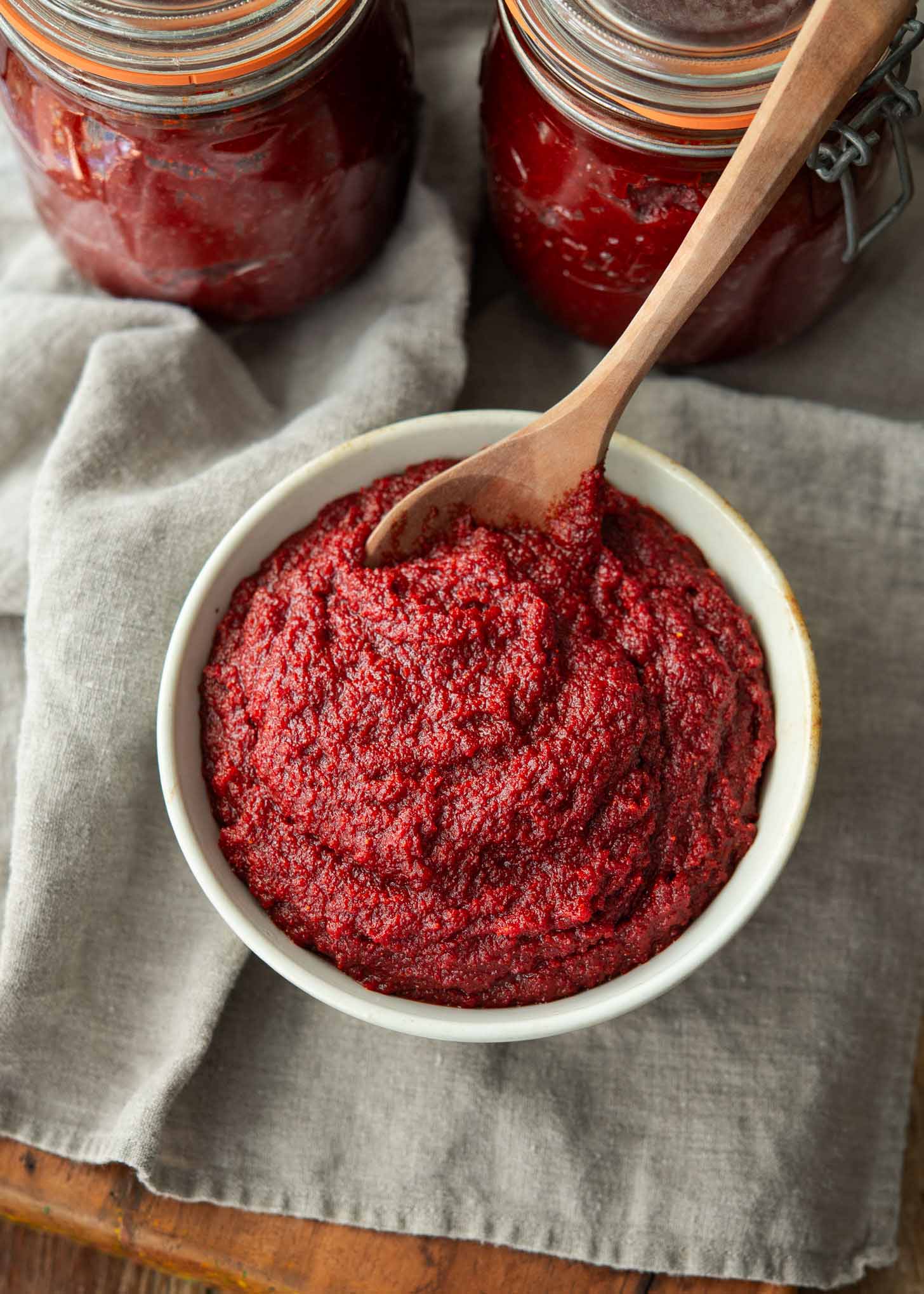 Homemade Korean chili paste divided in a bowl and glass jars.