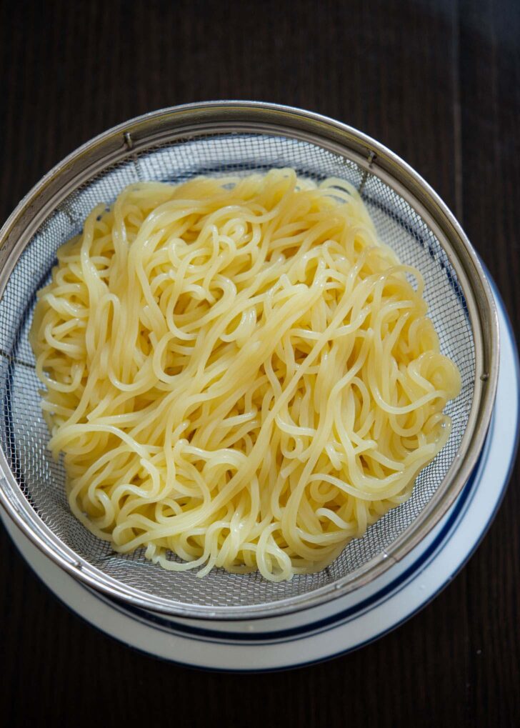 Cooked noodles drained in a colander.
