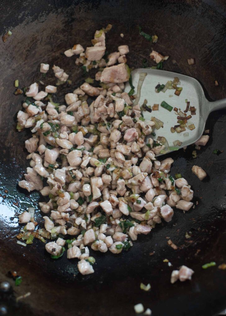 Pork pieces added to green onion and stir-fried together.