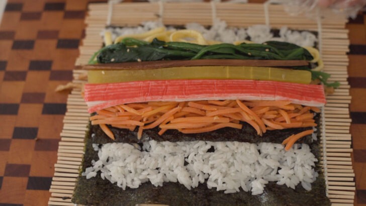 Kimbap fillings placed on the rice over seaweed.