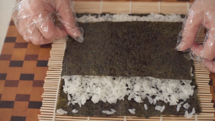A layer of seaweed placed on top of rice.