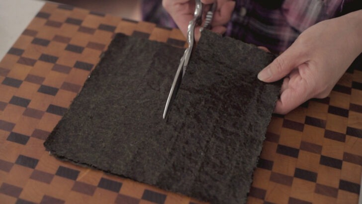 Dried seaweed sheets are cut in half.