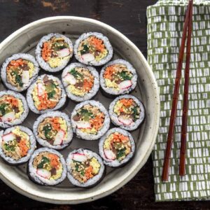 Kimbap slices are beautiful arranged in a serving dish.